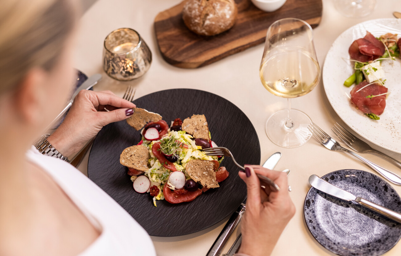 Eine Frau genießt ein kunstvoll angerichtetes Essen