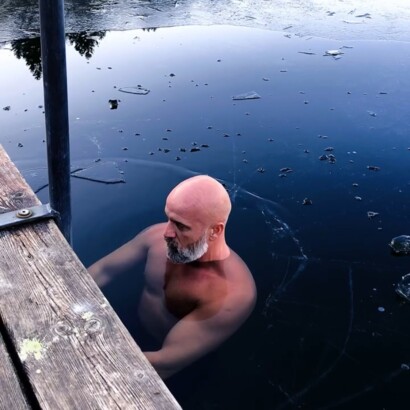 Mann badet im eiskalten See