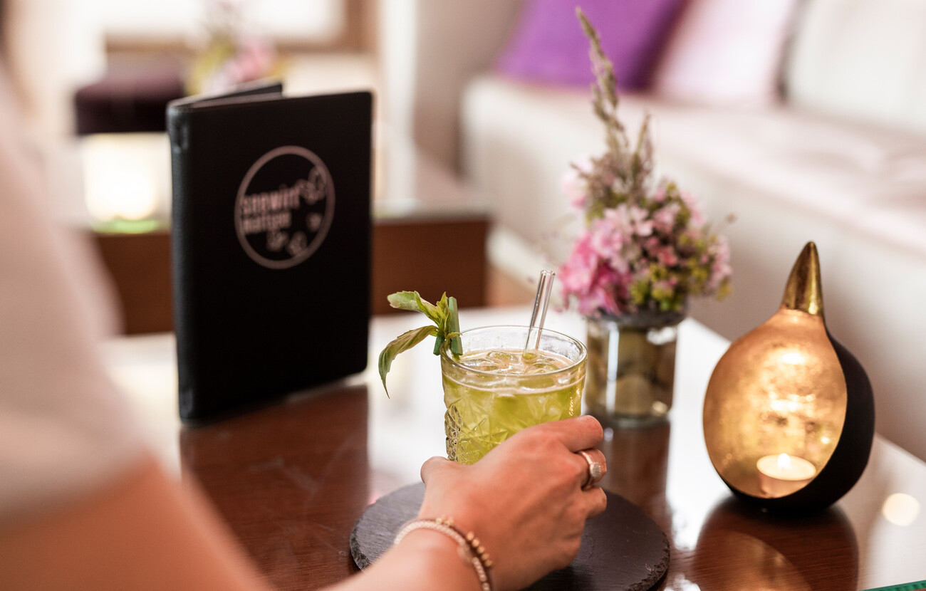 Eine Frau genießt einen Cocktail in der Hotelbar